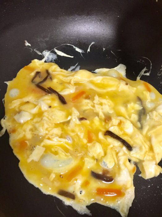 中華名菜 かに玉天心飯の卵を手早く半熟に焼き上げる。