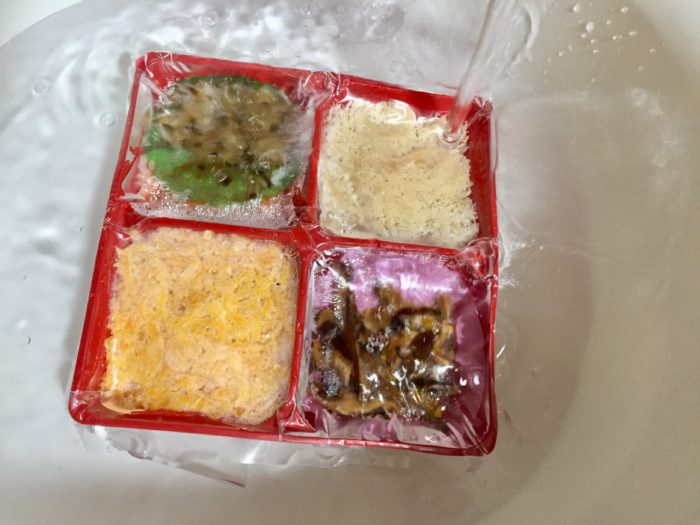 冷凍鶏飯の具材を流水解凍する。