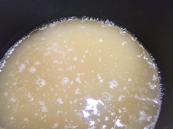 冷凍鶏飯のスープを鍋に入れて煮込んでいく。